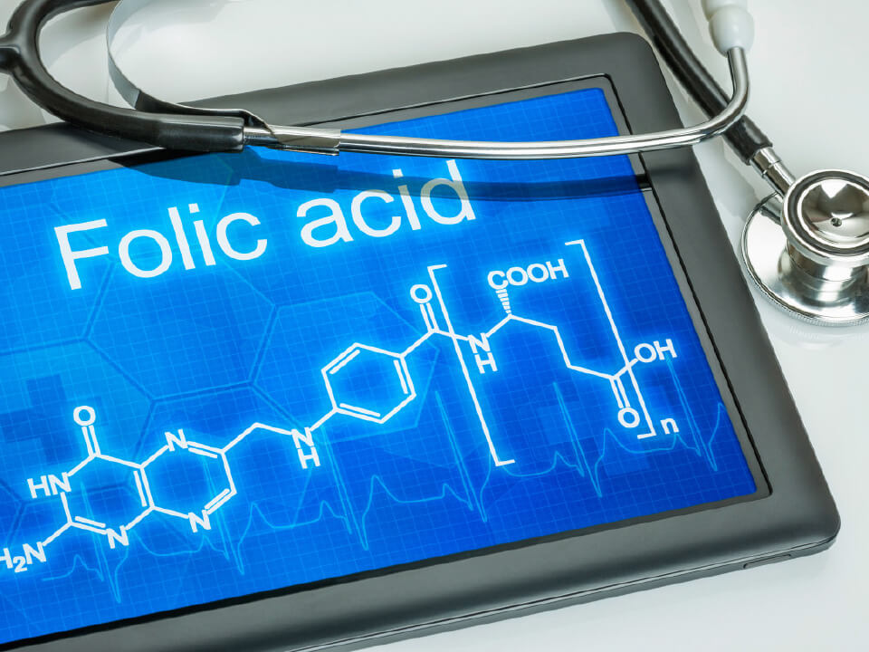 Natural Pharmaceuticals Movisan™ Collagen II Tablet z wyświetlonym wzorem chemicznym kwasu foliowego i stetoskopem, symbolizujące związek między witaminą a zdrowiem.